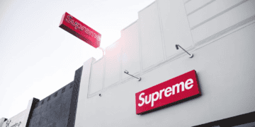 A Supreme store with a sign on the side of the building featuring an impressive Supreme T-Shirt Collection.
