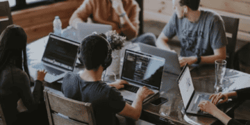 A group of people from Africa and China working on laptops at a table.