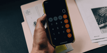 A person analyzing a proposed luxury goods tax using a calculator on their phone.