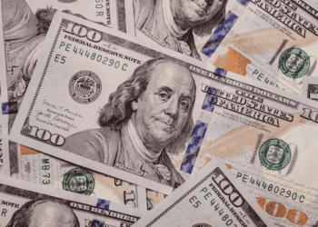 A pile of one hundred dollar bills representing investment opportunities on a white background.