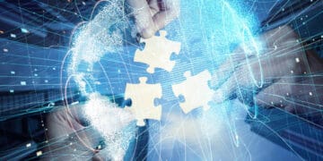 A hand holding a puzzle piece representing EU-Australia Free Trade Agreement in front of a globe.