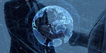 Two business people from Saudi Arabia shaking hands in front of a globe.