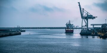 A ship is docked in a harbor, undergoing Customs Outlook and Compliance procedures as part of its involvement in Canadian Trade.