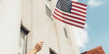 A woman waving an American flag in front of a building symbolizes the strong role America's allies play in export control measures.