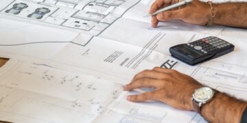 Team collaborating on blueprints, developing supply chain resilience plans. - Supply Chain News