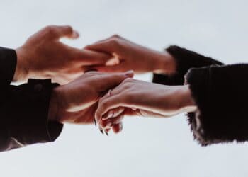 Several individuals joining hands together in a show of unity.