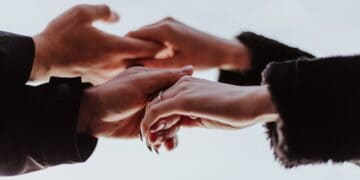 Several individuals joining hands together in a show of unity.
