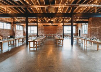 A wedding reception set up in an industrial warehouse transformed with a rustic ambiance.