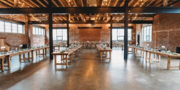 A wedding reception set up in an industrial warehouse transformed with a rustic ambiance.