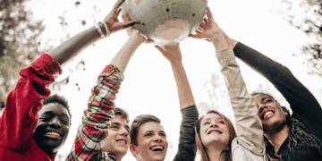 A group of youth holding up a globe, passionately advocating for equity and promoting corporate social responsibility.