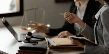 Two businesswomen reviewing documents, discussing CSR certification for Dutch enterprises. - Supply Chain News