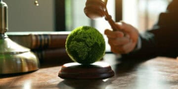Gavel over a globe covered in moss, symbolizing environmental law and climate change in Australia. - Supply Chain News