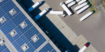 An aerial view of trucks parked in a parking lot with solar panels, showcasing sustainable supply chain practices in Latin America.