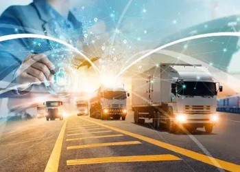 A man is driving a truck on a highway, envisioning the Future of Goods Movement.