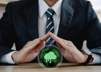 A businessman embracing an eco-friendly tree, symbolizing ethical sourcing and green energy initiatives.