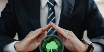 A businessman embracing an eco-friendly tree, symbolizing ethical sourcing and green energy initiatives.