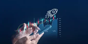Hands using a smartphone displaying an upward trending graph with a rocket launching, symbolizing growth and success. - Supply Chain News