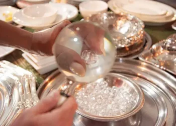 A person pouring silverware on a table, emphasizing the ethical sourcing and value of the formation.