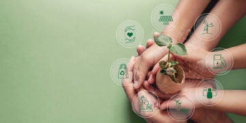 Hands holding a sprouting plant, symbolizing corporate social responsibility and sustainable practices. - Supply Chain News