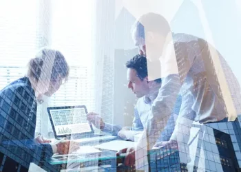 Business team analyzing data on laptop, showcasing integrated approach to ESG. - Supply Chain News