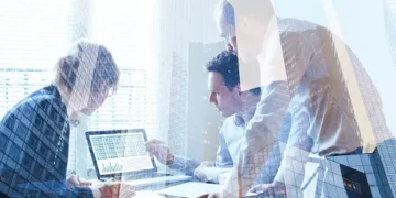 Business team analyzing data on laptop, showcasing integrated approach to ESG. - Supply Chain News