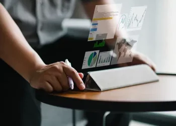 Person using tablet displaying graphs and data visualizations related to social impact and Microsoft Submittable partnership. - Supply Chain News