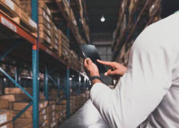 Warehouse worker using tablet to manage inventory. Streamlining logistics for SMEs. - Supply Chain News