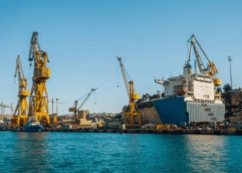 Large cargo ship in dry dock with multiple cranes. Green logistics in action. - Supply Chain News