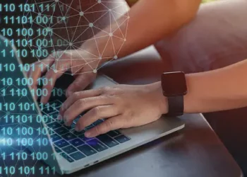 Person using laptop, EU cloud cybersecurity certification scheme concerns. - Supply Chain News