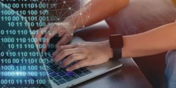 Person using laptop, EU cloud cybersecurity certification scheme concerns. - Supply Chain News