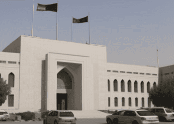 A white building with Afghan Central Bank flags flying in front of it, symbolizing independence and US Report influence.
