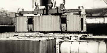 Cargo crane lifting shipping containers at a port, illustrating supply chain dynamics. - Supply Chain News