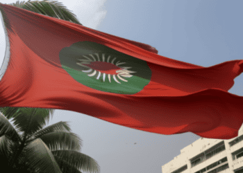 The flag of Bangladesh flies in front of a building amidst political turmoil.