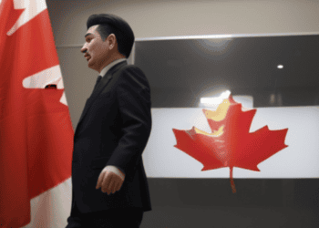 A man in a suit walking in front of the Canadian flag during an investigation on Uighur forced labor in Canada.