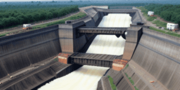 An aerial view of a dam with water flowing through it, contributing to electricity generation in India.