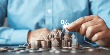 Hands arranging stacks of coins with upward trending graph and percentage symbol; illustrating financial growth. - Supply Chain News