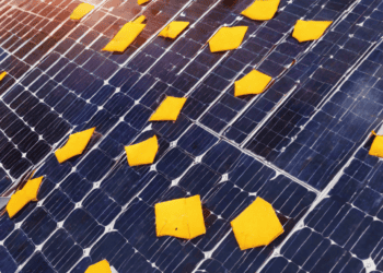 An analysis of the impact of solar tariffs on a solar panel covered in yellow pieces of paper.