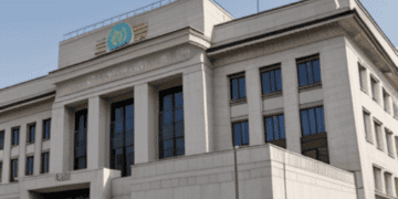 Turkey's Central Bank raises interest rate exceeding expectations, with a building displaying a flag on top.