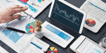 Businesspeople analyzing data charts and graphs on tablets and laptops for predictive risk profiling and supply chain cybersecurity. - Supply Chain News