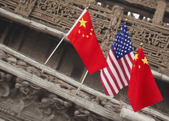 Three American and Chinese flags wave in front of an ornate building amidst the ongoing U.S.-China trade dispute.