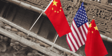 Three American and Chinese flags wave in front of an ornate building amidst the ongoing U.S.-China trade dispute.