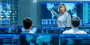 Cybersecurity experts at Con Edison conference, reviewing data on multiple monitors. - Supply Chain News