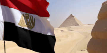 Egyptian flag waves near pyramids, reflecting Egypt's economic challenges. - Supply Chain News