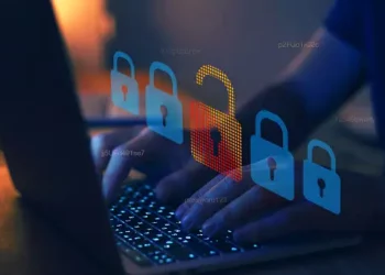 Person's hands typing on laptop with cybersecurity lock icons; data breach prevention. - Supply Chain News