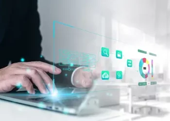 Businessperson using laptop, innovative IoT security research data visualized. - Supply Chain News