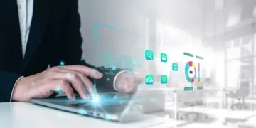 Businessperson using laptop, innovative IoT security research data visualized. - Supply Chain News