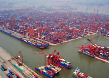 Aerial view of a bustling Chinese port, showcasing numerous cargo ships and containers within a large free trade zone. - Supply Chain News
