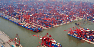 Aerial view of a bustling Chinese port, showcasing numerous cargo ships and containers within a large free trade zone. - Supply Chain News