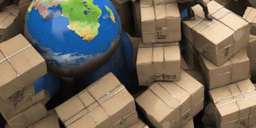 A man standing in a pile of boxes, symbolizing trade relations, with a globe in the middle.