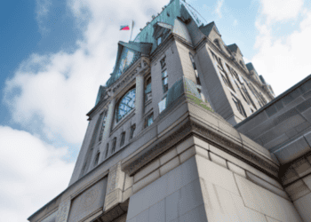 The Royal Bank of Canada, a building with a clock on top of it, faces job cuts amidst economic downturn.